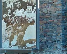 Part of the Hector Pieterson Memorial in Soweto, South Africa. A news photograph of Hector's limp body being carried away after being shot by police is visible.